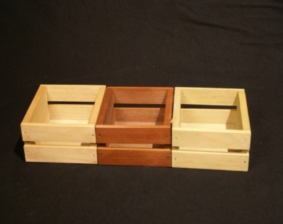 Three mini open-top custom wood crates side by side. The middle crate is stained.